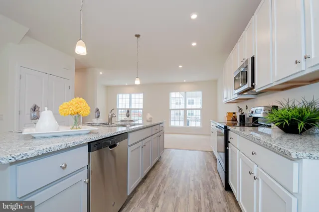 a kitchen with granite countertop kitchen island white cabinets and stainless steel appliances