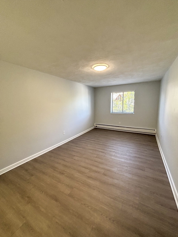 505 Washington, Unit 46 Chelsea, MA 02150 - Photo 13 of 16 an empty room with wooden floor and windows