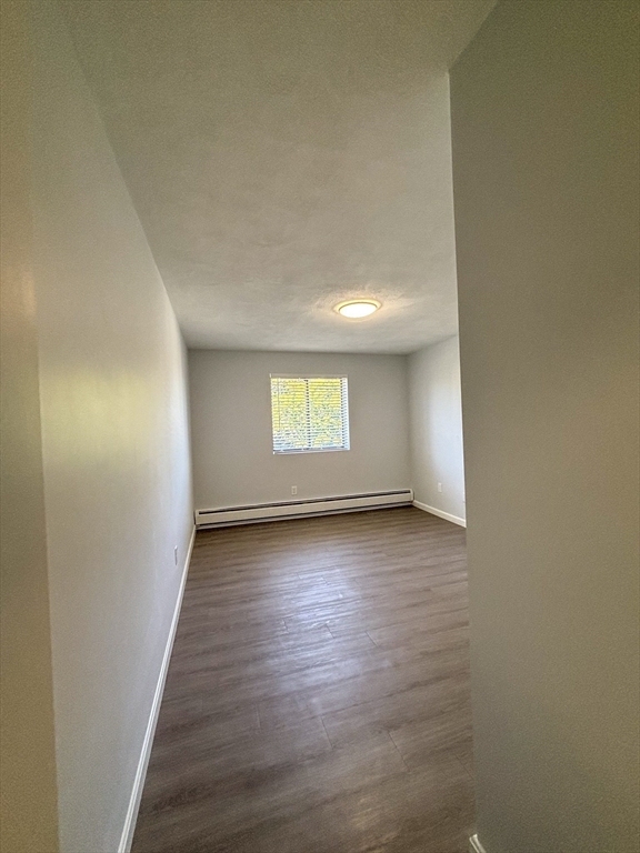 505 Washington, Unit 46 Chelsea, MA 02150 - Photo 15 of 16 an empty room with wooden floor and windows