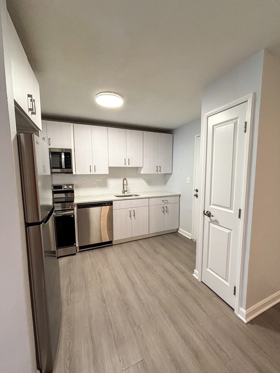 505 Washington, Unit 46 Chelsea, MA 02150 - Photo 3 of 16 a kitchen with a refrigerator a sink and cabinets