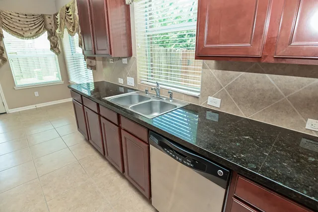 a kitchen with granite countertop a sink and a stove