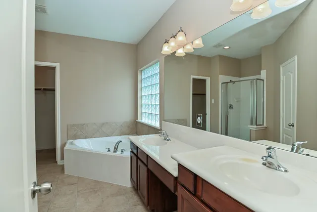 a bathroom with a tub a sink and mirror