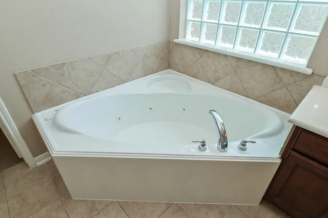 a bath tub sitting in a bathroom next to a window