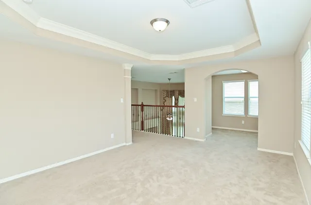 an empty room with a window and kitchen view