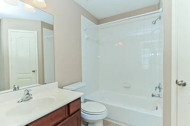 a bathroom with a bathtub shower sink vanity and toilet