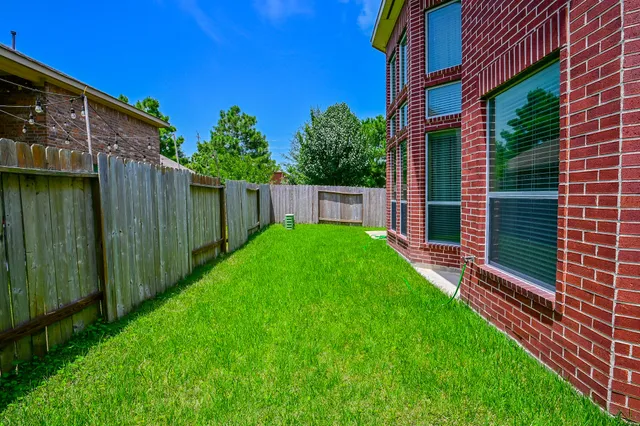 a view of backyard with potted plants and wooden fence