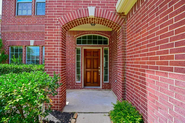 a view of a brick house with plants
