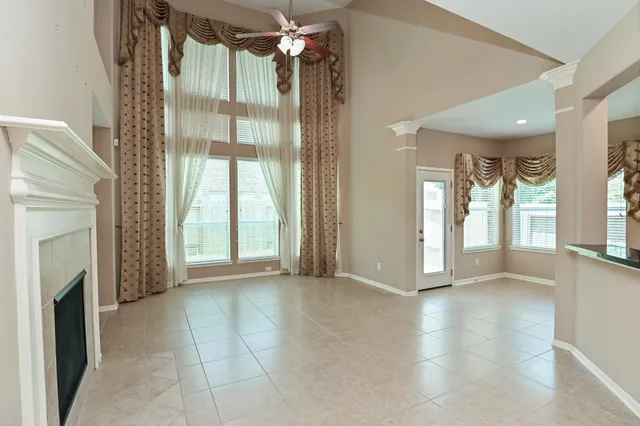 a view of an empty room with a fireplace and a window