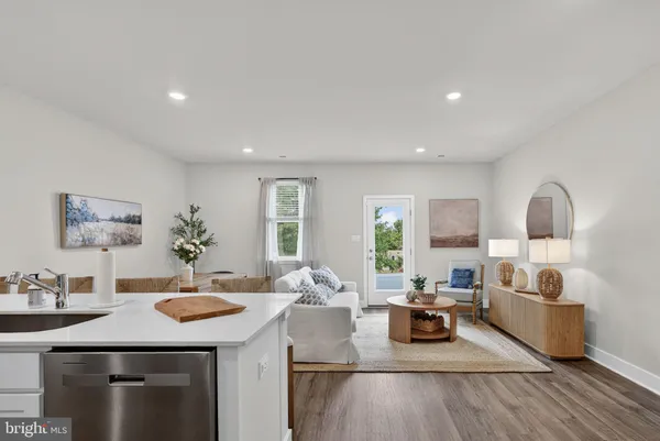 a kitchen with stainless steel appliances kitchen island granite countertop a dining table chairs sink and cabinets