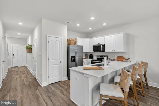 a kitchen that has a lot of cabinets a sink and appliances