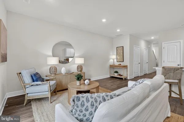 a living room with furniture and a dining table with wooden floor