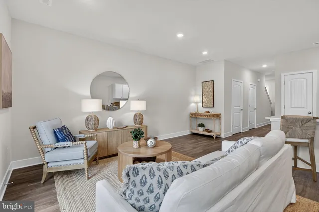 a living room with furniture and a dining table with wooden floor