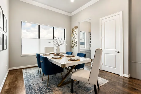 a dining room with wooden floor and large windows