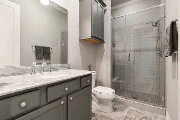 a spacious bedroom with a bed a table and large mirror