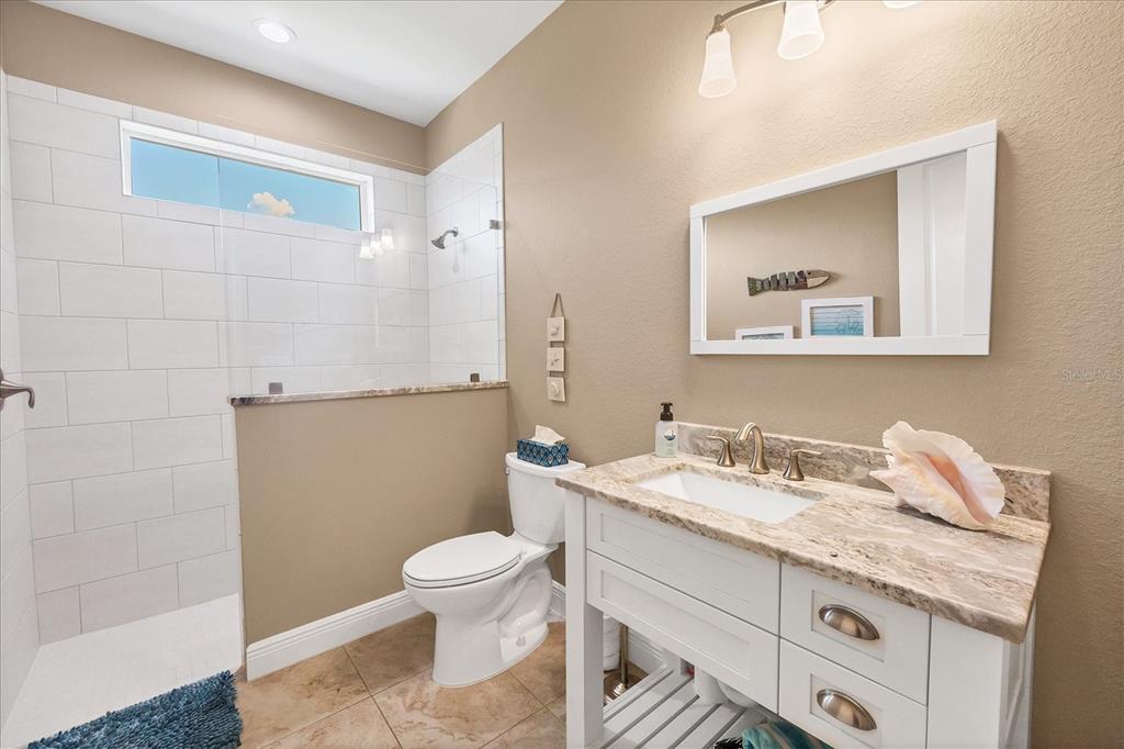 34 Brig Circle South Placida, FL 33946 - Photo 21 of 39 a bathroom with a granite countertop sink a toilet and a mirror