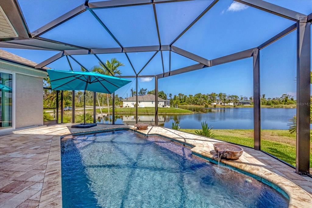 34 Brig Circle South Placida, FL 33946 - Photo 25 of 39 a view of a swimming pool with a table and chairs under an umbrella