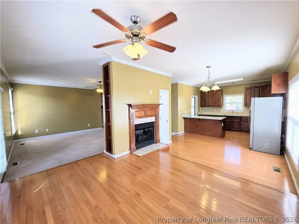 a view of a livingroom with a fireplace a sink and a ceiling fan