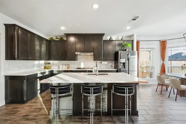 a kitchen with cabinets and chairs