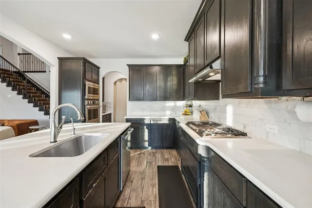 a kitchen with stainless steel appliances granite countertop a sink stove and refrigerator
