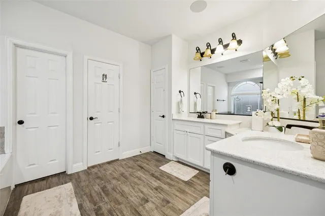 a spacious bathroom with a sink mirror and vanity