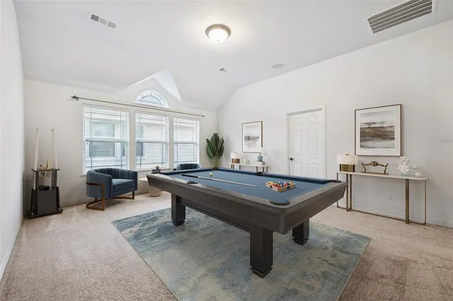a room with furniture pool table and windows