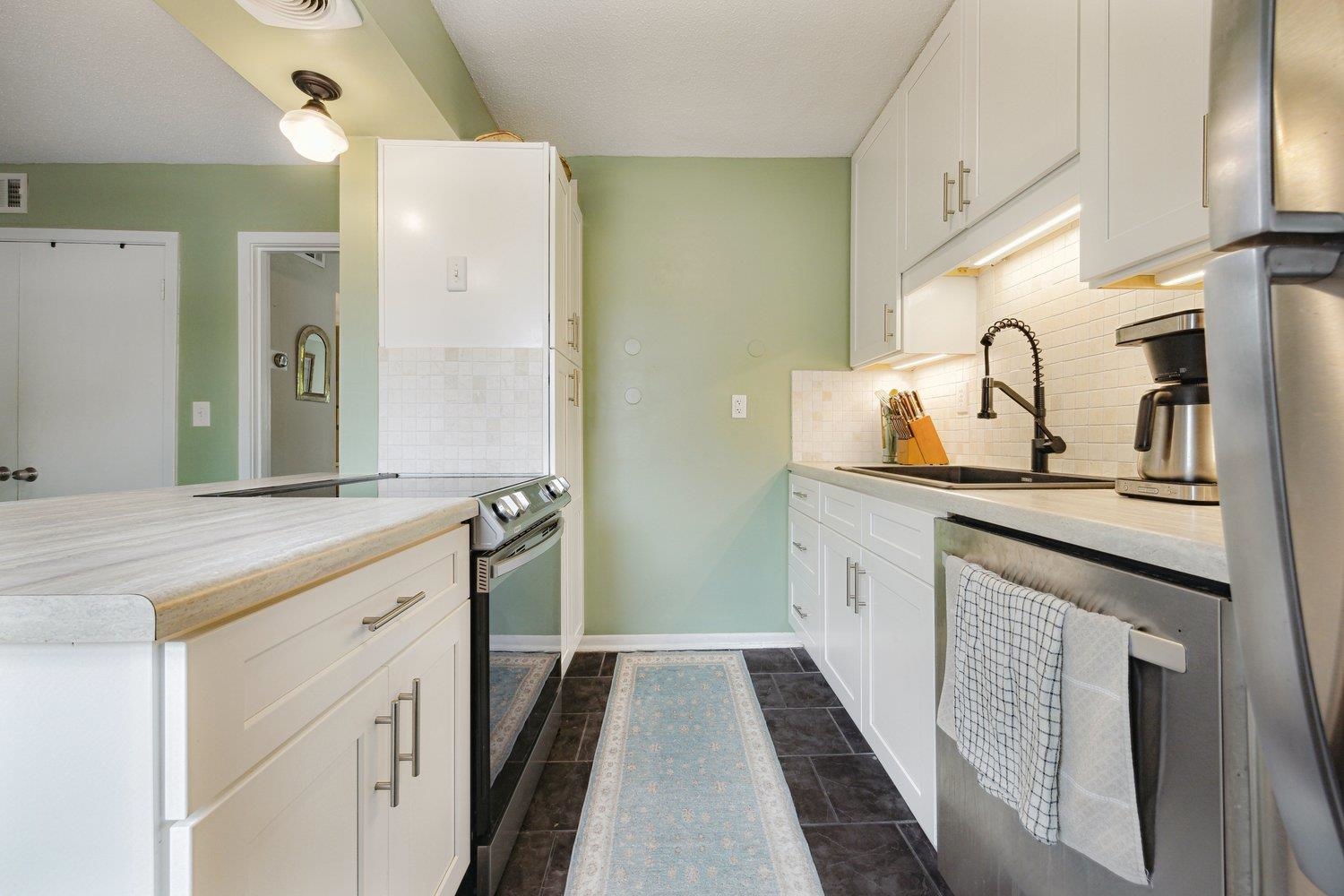 1005 June Road Memphis, TN 38119 - Photo 11 of 22 Kitchen featuring a sink, appliances with stainless steel finishes, backsplash, and light countertops