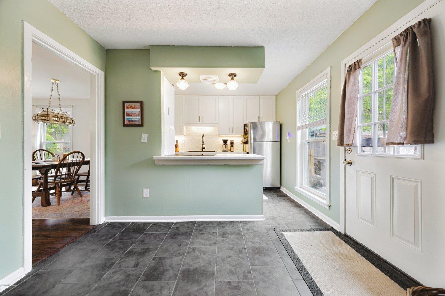 1005 June Road Memphis, TN 38119 - Photo 14 of 22 Kitchen featuring freestanding refrigerator, white cabinets, an inviting chandelier, and a wealth of natural light