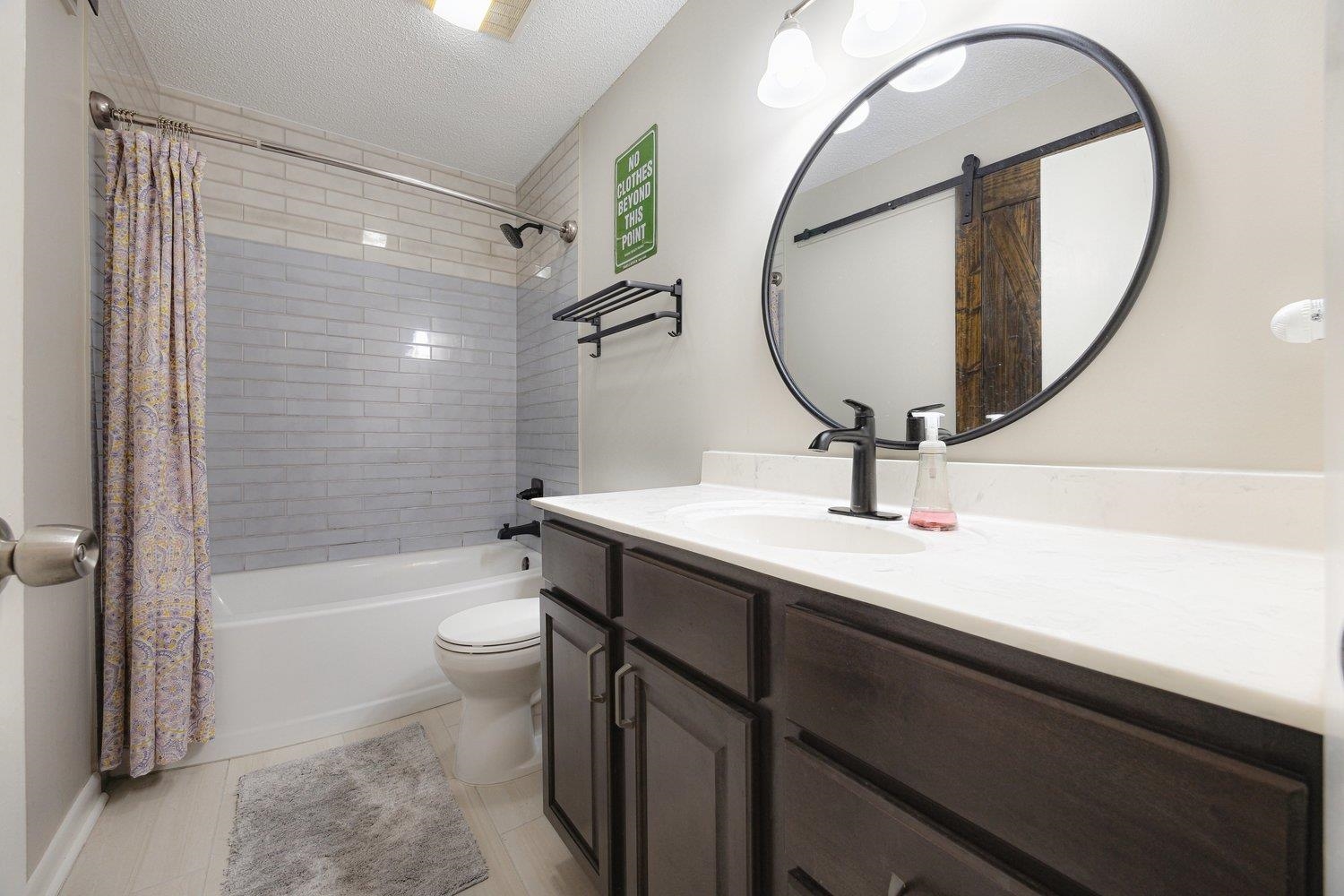 1005 June Road Memphis, TN 38119 - Photo 19 of 22 Full bath with shower / bath combo with shower curtain, tile patterned flooring, vanity, toilet, and a textured ceiling