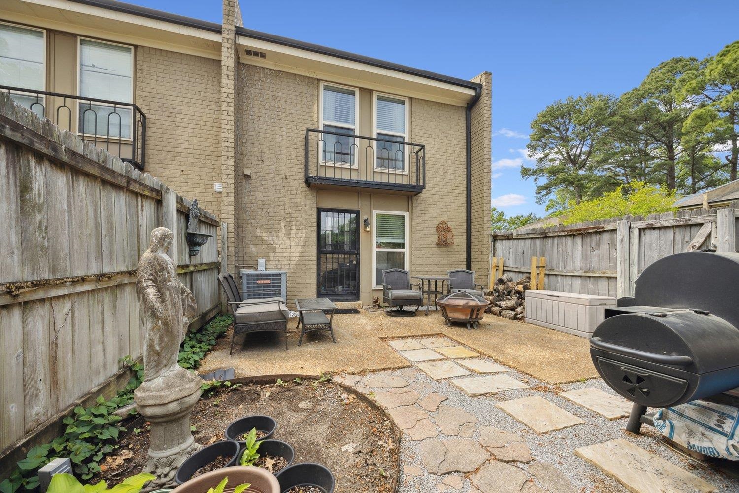1005 June Road Memphis, TN 38119 - Photo 21 of 22 Rear view of property with brick siding, a balcony, a fenced backyard, an outdoor fire pit, and a patio