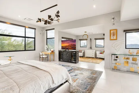a bedroom with a bed a large window and flat screen tv