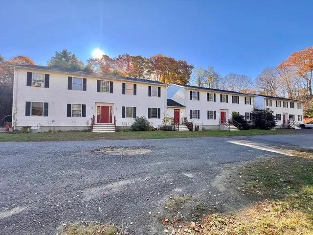 a view of a big house with a big yard and large trees