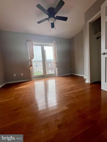 a view of an empty room with window and wooden floor