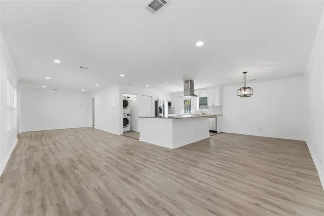 a view of kitchen with kitchen island sink and living room