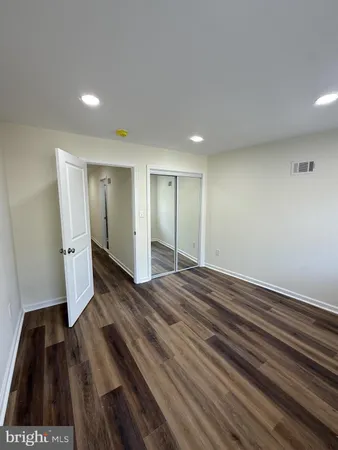 a view of empty room with wooden floor and window