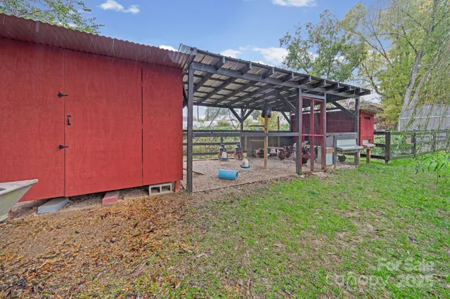 a view of a garden with a bench in front of the house