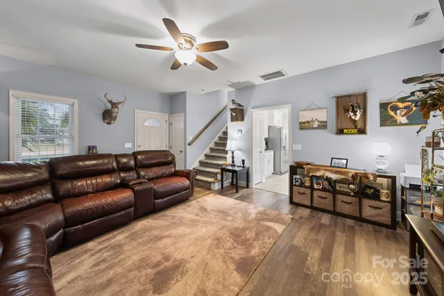 a living room with furniture and a ceiling fan