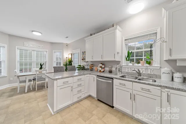 a kitchen with granite countertop a sink stainless steel appliances and cabinets