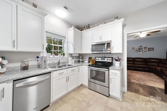 a kitchen with white cabinets and stainless steel appliances