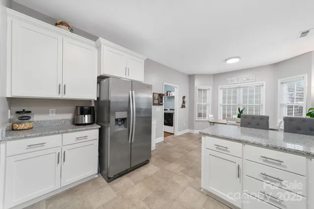 a kitchen with granite countertop white cabinets and a sink