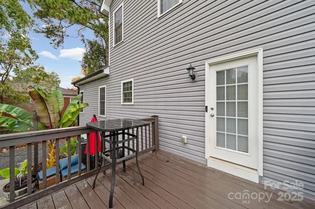 a view of a roof deck with wooden floor and fence and a floor to ceiling window