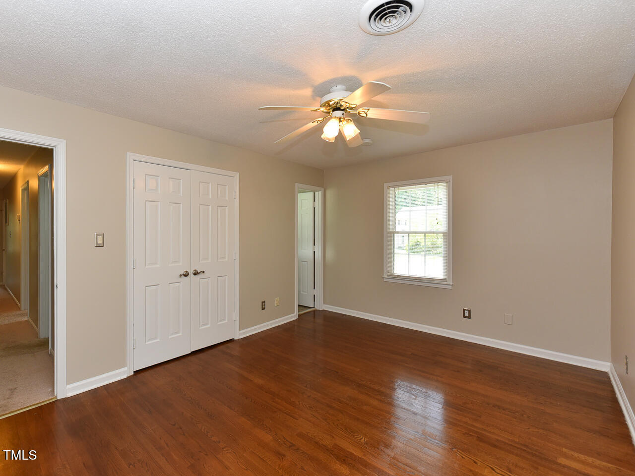 1215 Brookgreen Drive Cary, NC 27511 - Photo 16 of 40 an empty room with wooden floor fan and windows