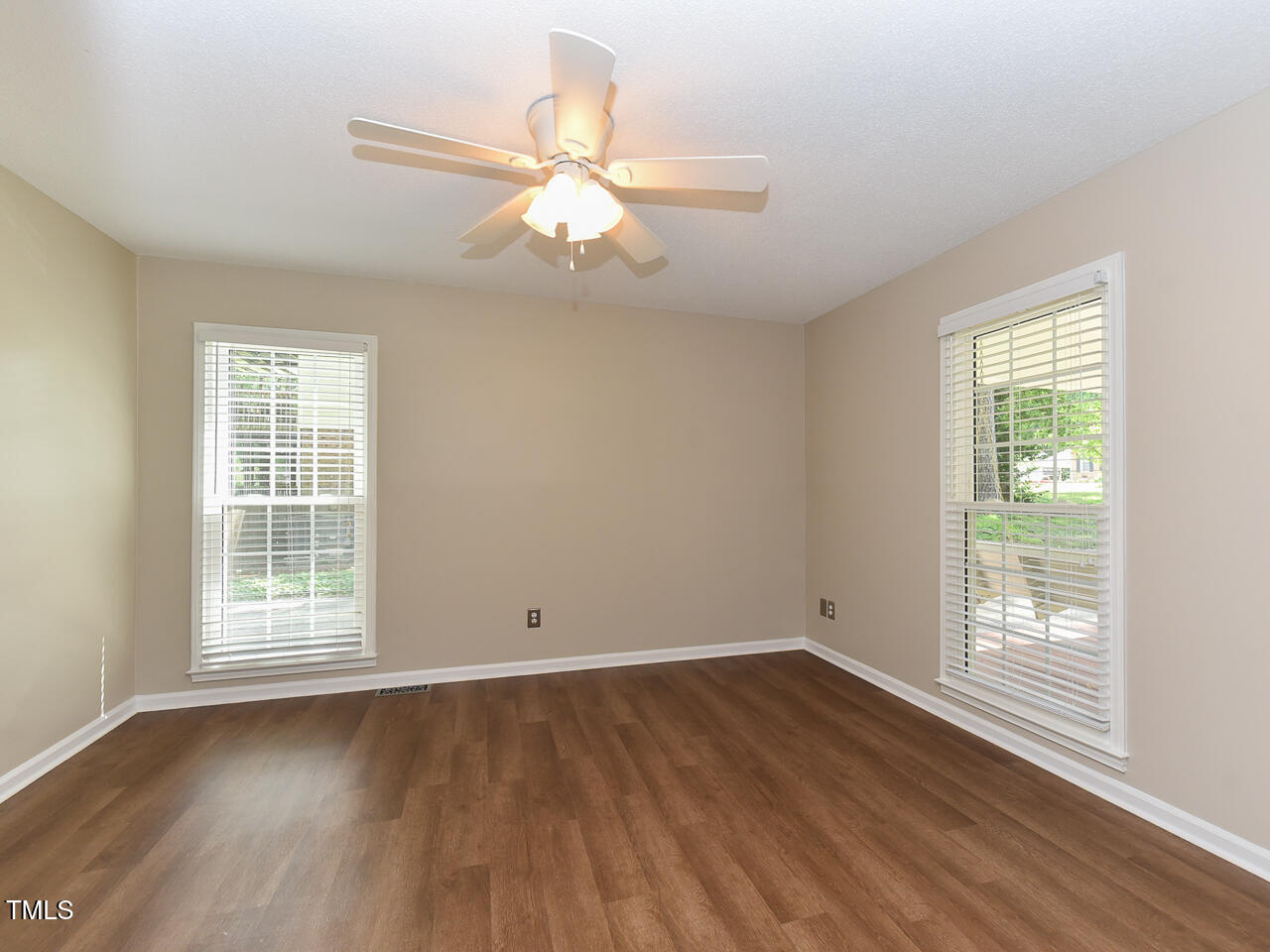 1215 Brookgreen Drive Cary, NC 27511 - Photo 25 of 40 an empty room with wooden floor fan and windows