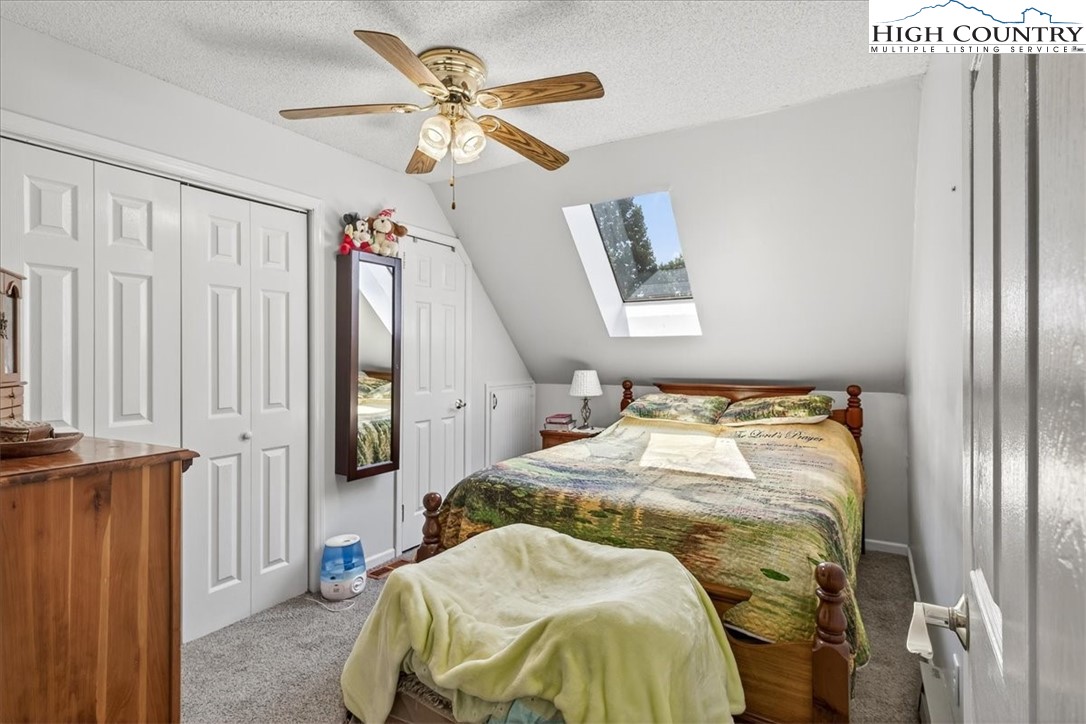 370 Osee Road Sparta, NC 28675 - Photo 16 of 36 a bedroom with a bed and a chandelier