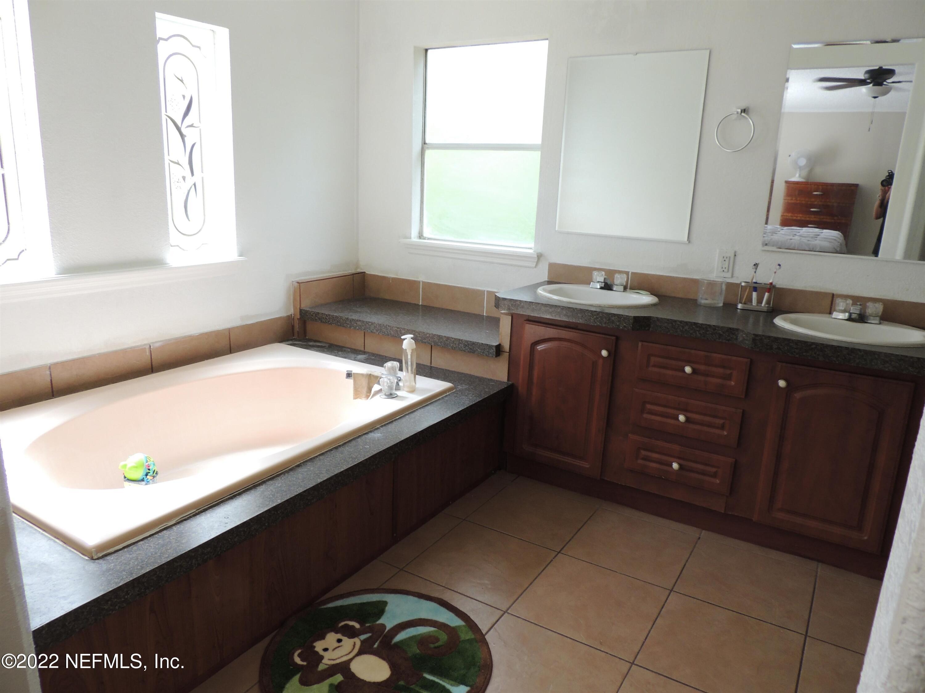 1801 Forbes Road St. Augustine, FL 32092 - Photo 11 of 28 a bath room with a sink a mirror and a window