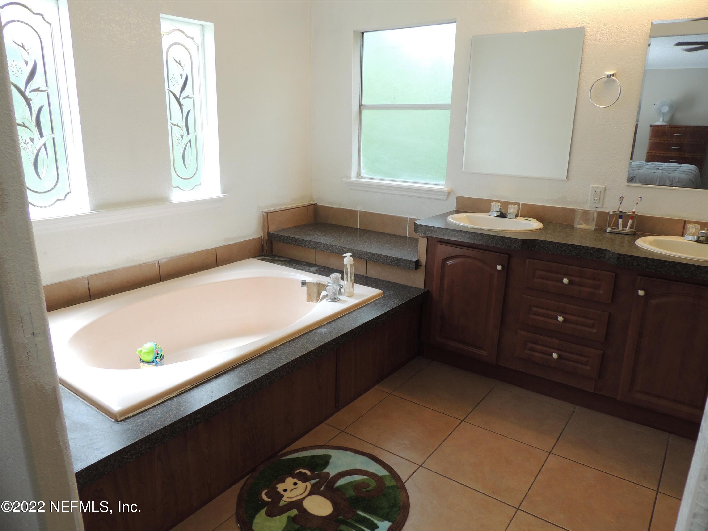 1801 Forbes Road St. Augustine, FL 32092 - Photo 12 of 28 a bathroom with a tub sink and mirror