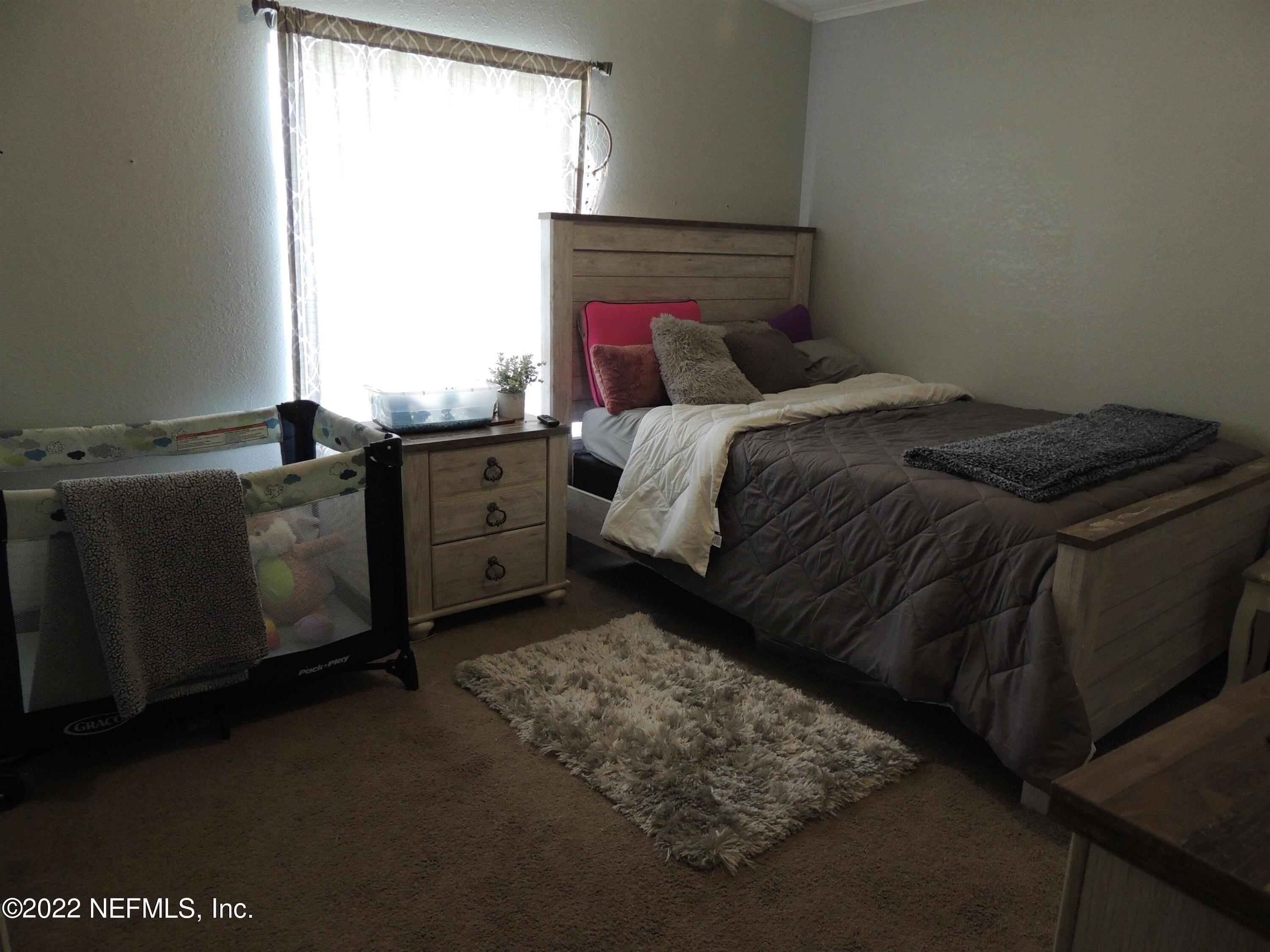 1801 Forbes Road St. Augustine, FL 32092 - Photo 14 of 28 a bed sitting in a bedroom next to a window