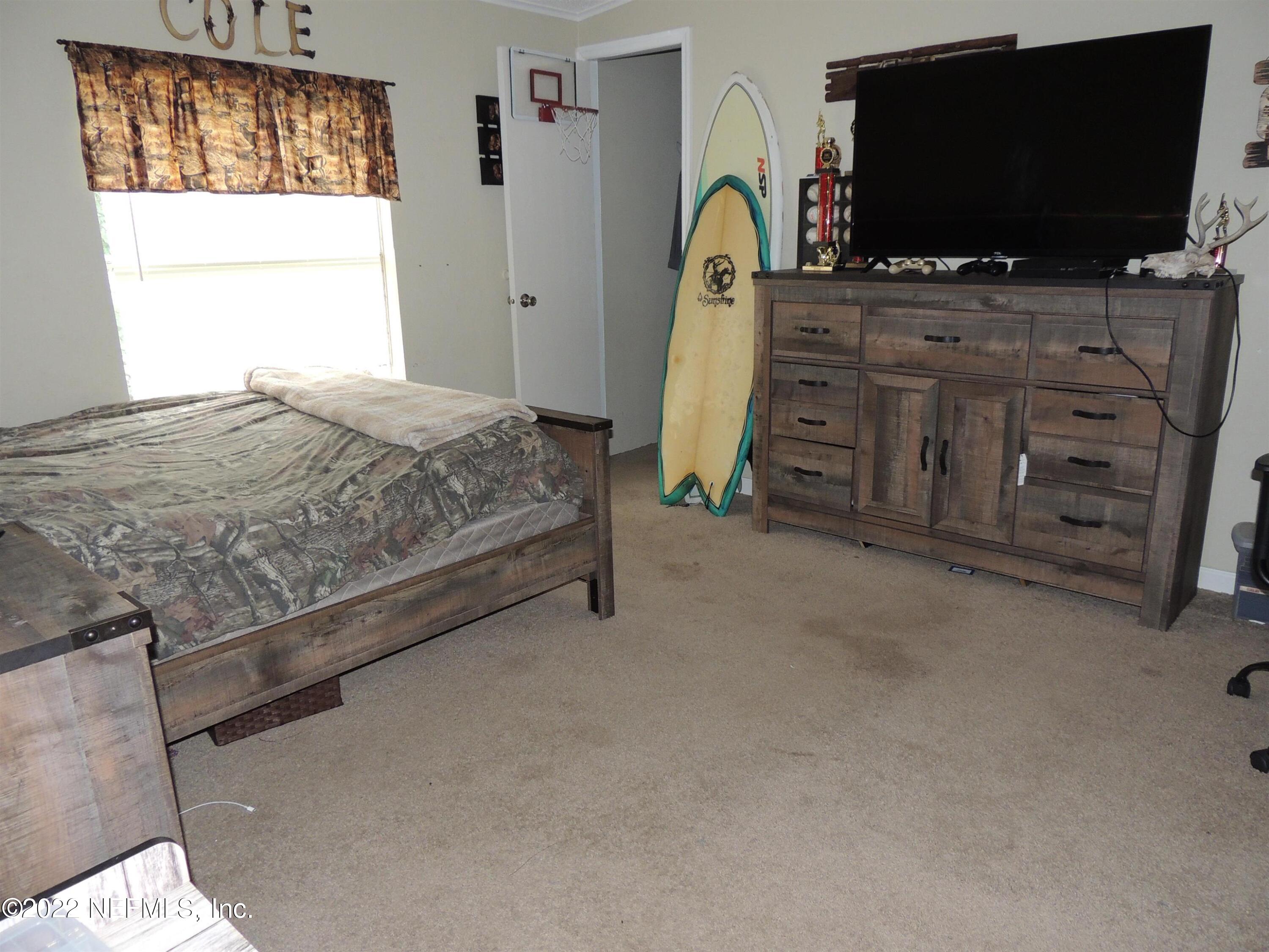 1801 Forbes Road St. Augustine, FL 32092 - Photo 15 of 28 a bedroom with a flat screen tv and a window