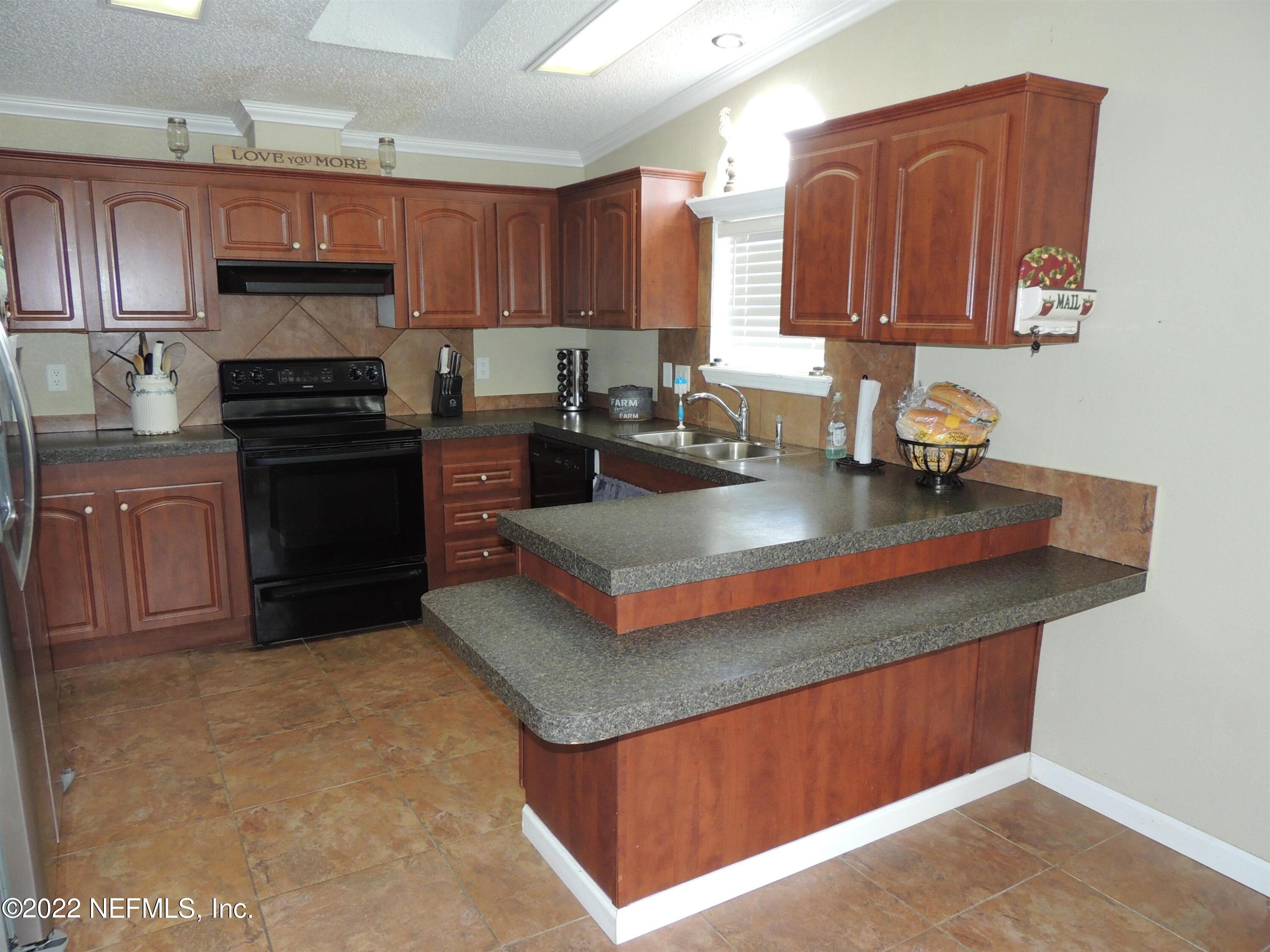 1801 Forbes Road St. Augustine, FL 32092 - Photo 3 of 28 a kitchen with stainless steel appliances granite countertop a stove a sink and a refrigerator