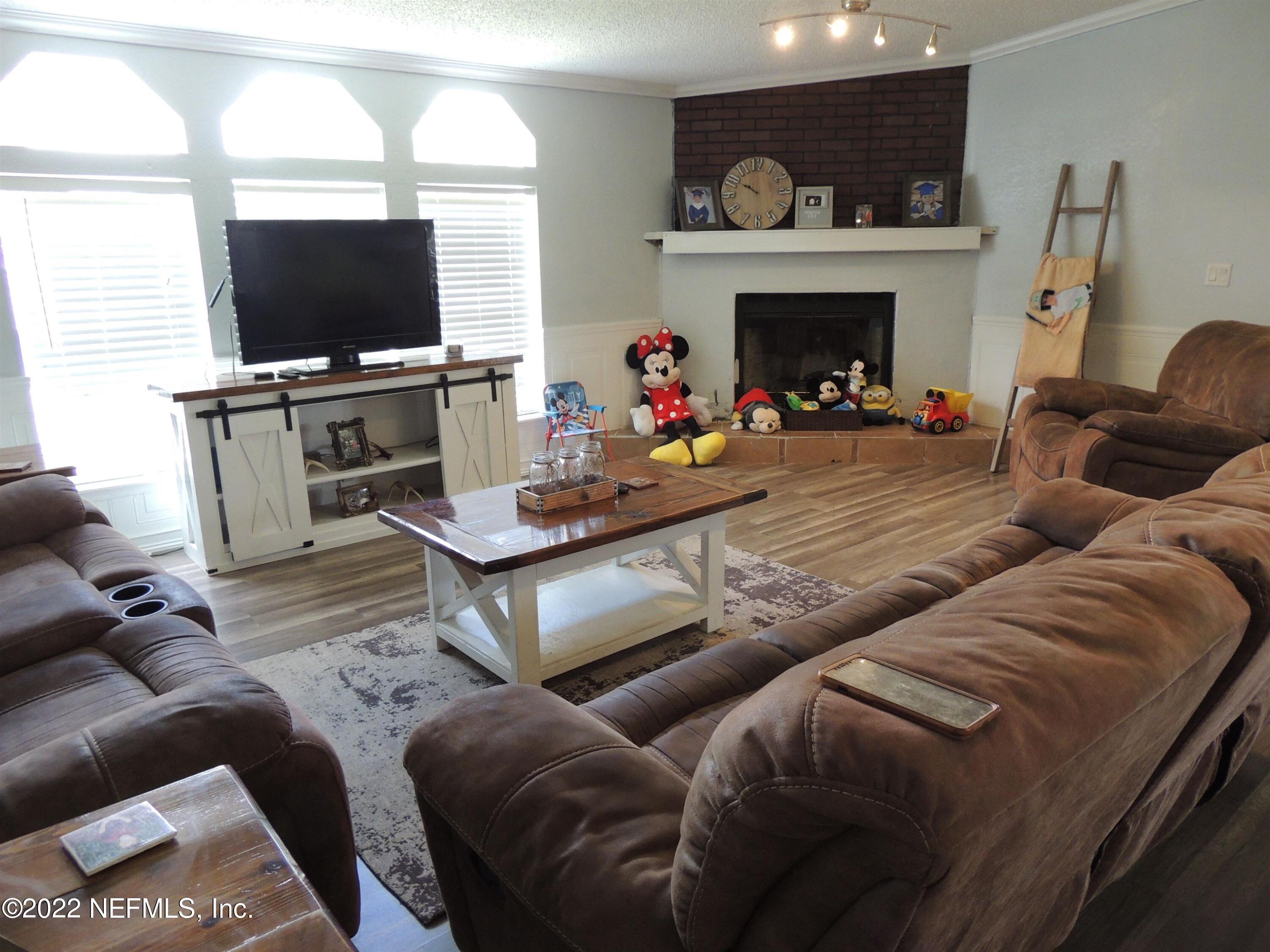 1801 Forbes Road St. Augustine, FL 32092 - Photo 8 of 28 a living room with furniture a fireplace and a flat screen tv