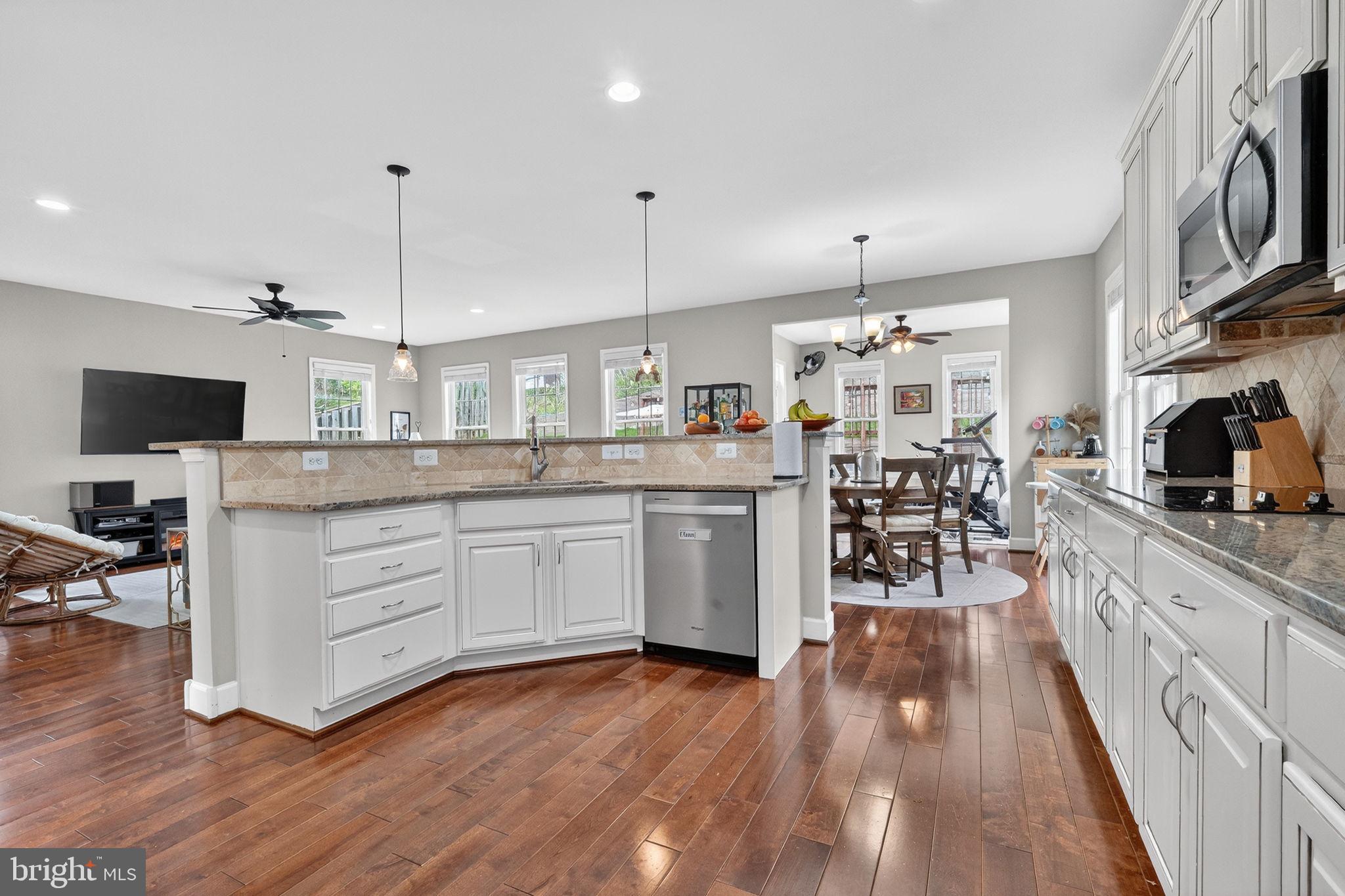 3112 Spring Drive Alexandria, VA 22306 - Photo 18 of 58 a kitchen with stainless steel appliances kitchen island granite countertop a stove a sink and white cabinets with wooden floor